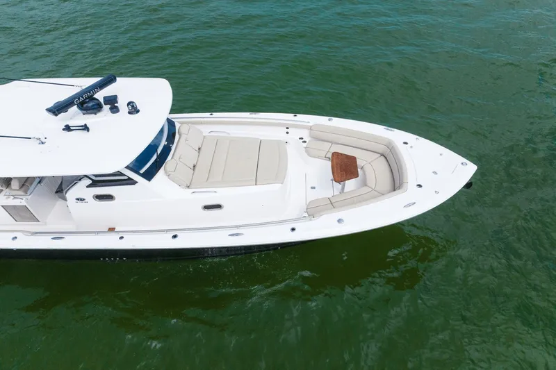 Pirates Bight Yacht Photos Pics 2019 Pursuit 408 boat with spacious seating and table on calm green water.