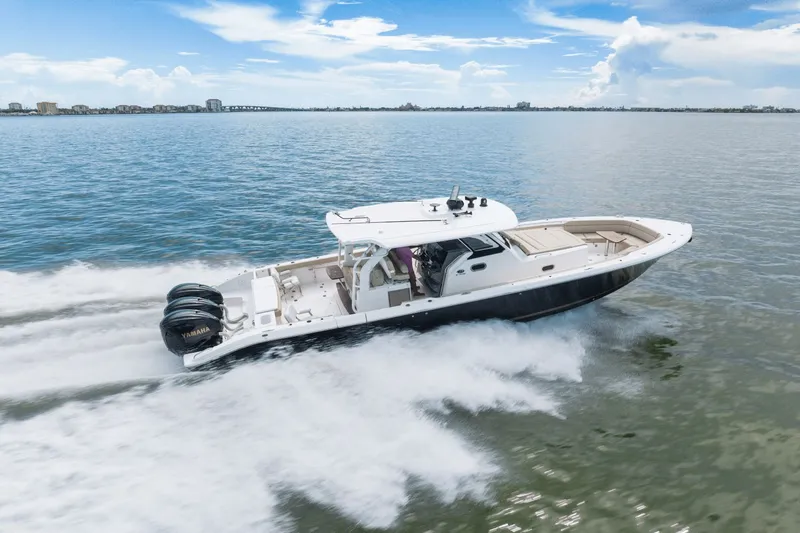 Pirates Bight Yacht Photos Pics 2019 Pursuit 408 boat cruising on open water under a clear blue sky.