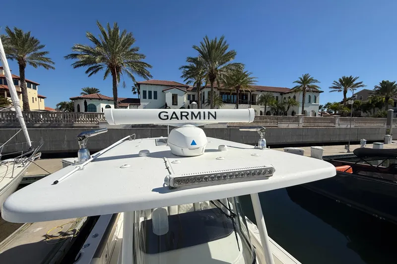  Yacht Photos Pics 2021 World Cat 295 CC boat with Garmin radar, docked near palm trees and luxury homes.