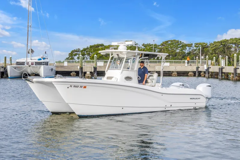  Yacht Photos Pics 2021 World Cat 295 CC boat cruising near a marina with clear skies.