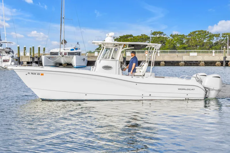  Yacht Photos Pics 2021 World Cat 295 CC boat cruising in a marina under a clear blue sky.