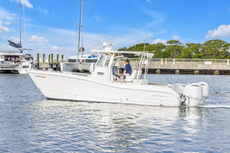  Yacht Photos Pics 2021 World Cat 295 CC boat cruising in a marina under a clear blue sky.