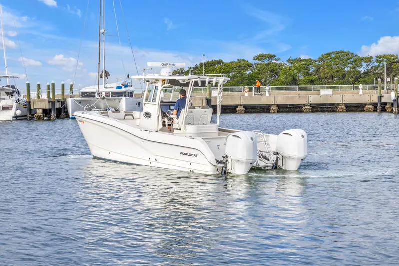  Yacht Photos Pics 2021 World Cat 295 CC boat cruising near a marina under a clear blue sky.