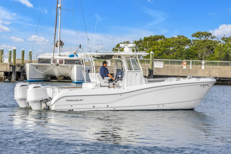  Yacht Photos Pics 2021 World Cat 295 CC boat cruising near marina, clear sky, calm water.
