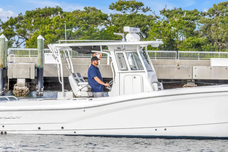  Yacht Photos Pics 2021 World Cat 295 CC boat with a person at the helm, dockside view.