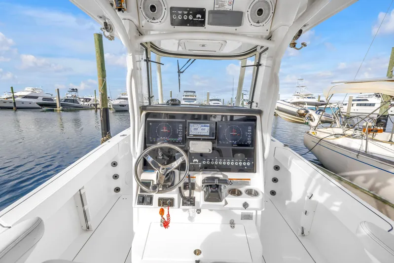  Yacht Photos Pics 2021 World Cat 295 CC boat dashboard with steering wheel and navigation controls at marina.