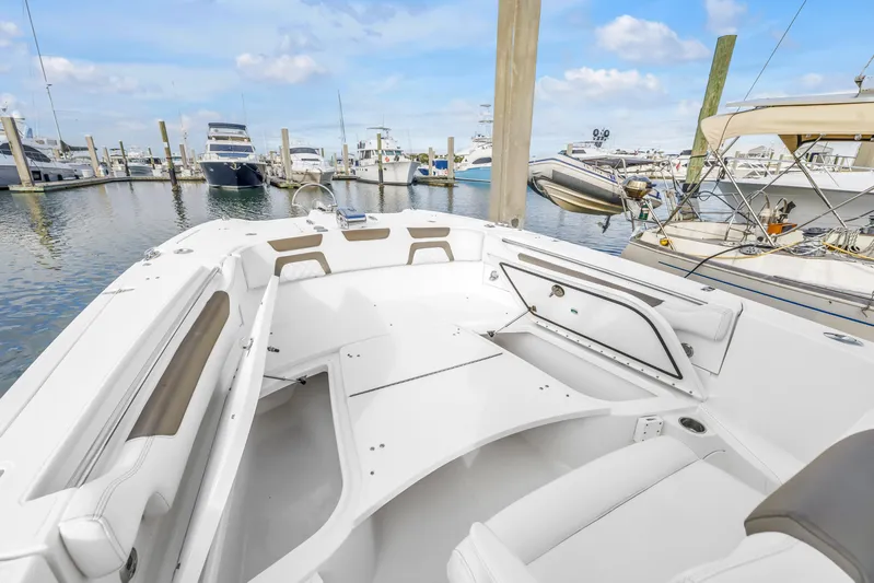  Yacht Photos Pics 2021 World Cat 295 CC boat interior at marina, showcasing seating and storage.