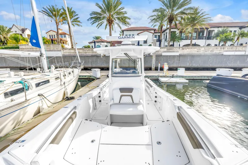  Yacht Photos Pics 2021 World Cat 295 CC boat docked at marina with palm trees and luxury homes.