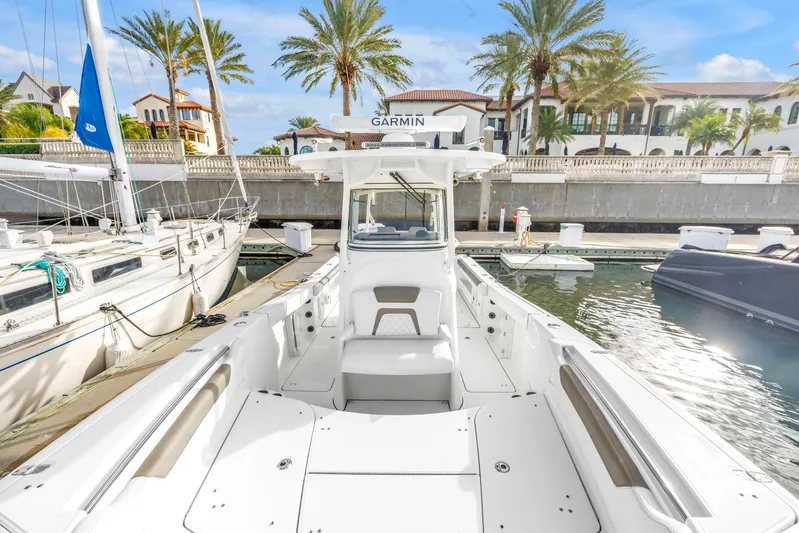  Yacht Photos Pics 2021 World Cat 295 CC boat docked in a marina with palm trees and luxury homes.