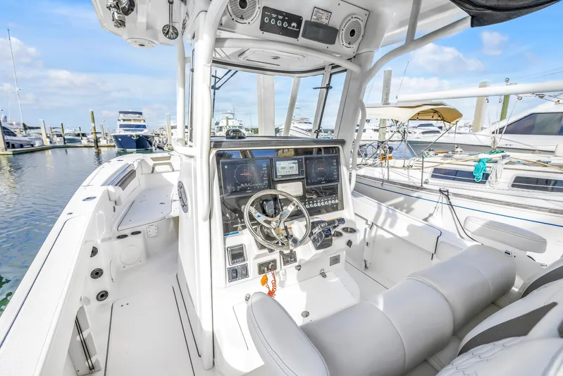  Yacht Photos Pics 2021 World Cat 295 CC boat interior with modern dashboard and steering wheel at marina.