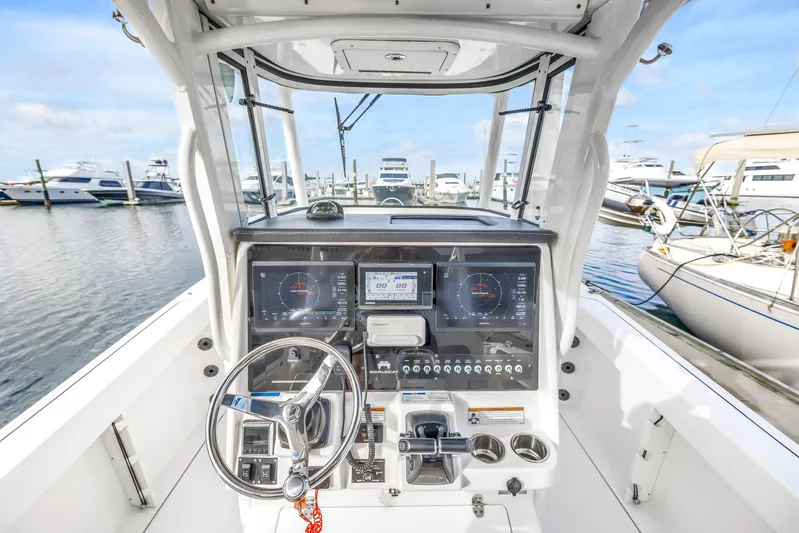  Yacht Photos Pics 2021 World Cat 295 CC boat dashboard with steering wheel and navigation displays at marina.