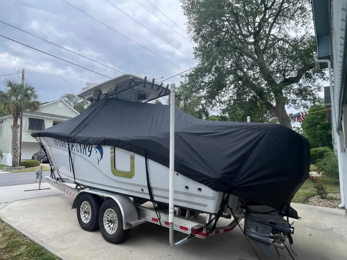  Yacht Photos Pics 2024 Sea Fox 288 Commander boat covered on a trailer in a residential driveway.