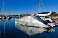 Covered 2022 Saxdor 320 GTO with Twin Mercury 300 V8 engines docked in marina.