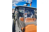 2022 Saxdor 320 GTO boat with clear canopy, docked under a blue sky.
