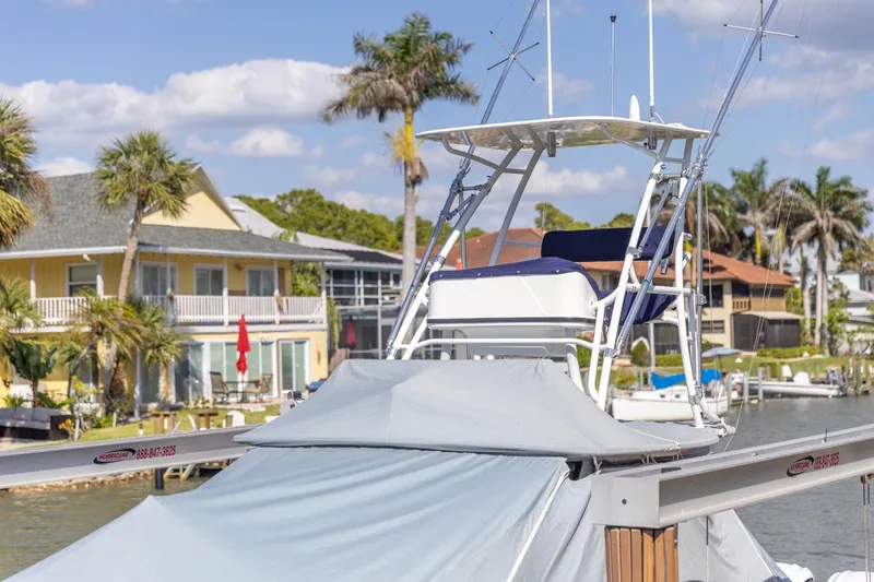  Yacht Photos Pics 2023 Edgewater 370CC boat docked near waterfront homes with palm trees.