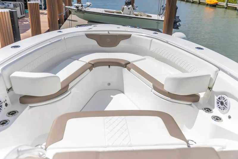  Yacht Photos Pics 2023 Edgewater 370CC boat interior with white and beige seating, docked by the water.