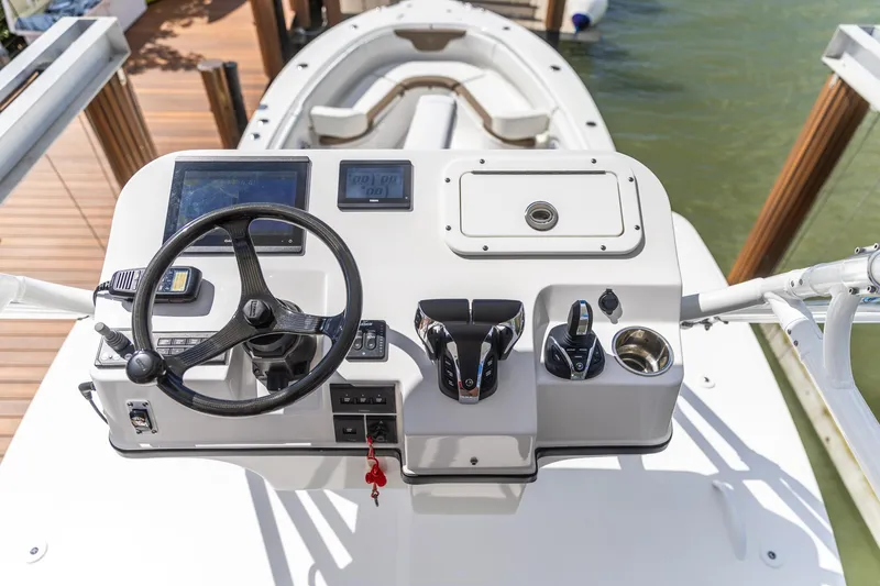  Yacht Photos Pics Edgewater 370CC 2023 boat helm with steering wheel and controls, docked by the water.