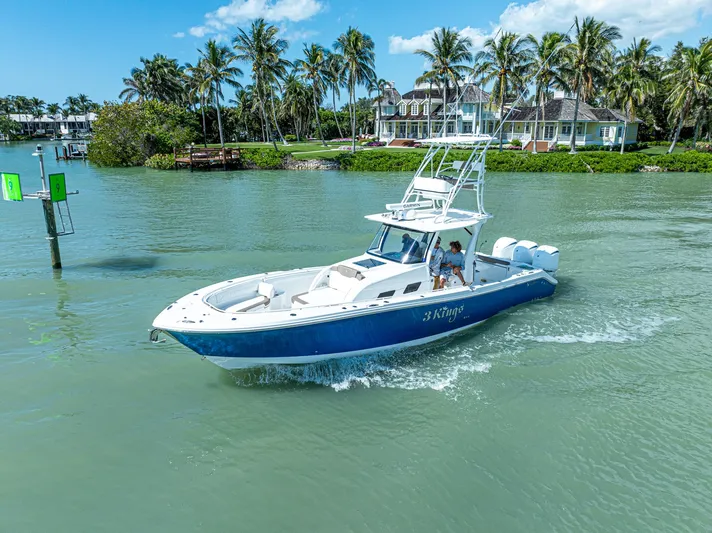  Yacht Photos Pics 2023 Edgewater 370CC boat cruising on a tropical waterway with palm trees.