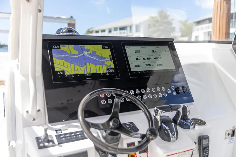  Yacht Photos Pics 2023 Edgewater 370CC boat dashboard with navigation screens and steering wheel.