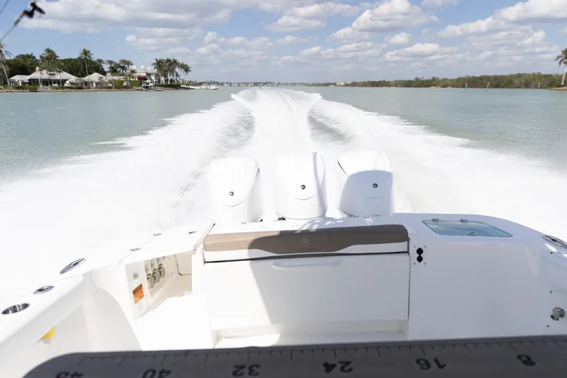  Yacht Photos Pics 2023 Edgewater 370CC boat speeding on a sunny day, leaving a wake trail.