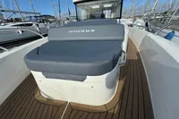 2023 Nimbus C11 boat with cushioned seating on teak deck, docked at marina.