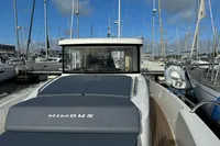 2023 Nimbus C11 boat docked in a marina, surrounded by sailboats under a clear blue sky.