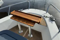 2023 Nimbus C11 boat with wooden table and cup holders on deck.