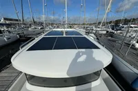 2023 Nimbus C11 yacht with solar panels docked at a marina under a clear blue sky.