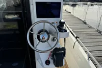 Helm of 2023 Nimbus C11 boat with steering wheel and control panel at marina.