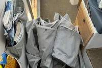 Interior of a 2023 Nimbus C11 boat with folded gray fabric and storage pockets.