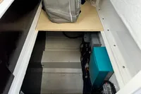 Storage compartment in a 2023 Nimbus C11 boat, featuring electrical components and a bag.