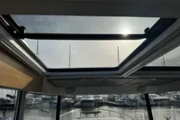 Sunroof view from 2023 Nimbus C11 boat, overlooking marina with moored boats.