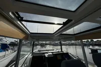 Interior view of 2023 Nimbus C11 boat with sunroof and marina background.