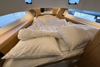 Cozy cabin bed in 2023 Nimbus C11 boat with plush pillows and bedding.