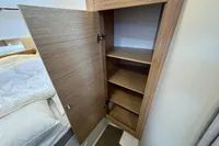 Wooden cabinet with open door and shelves in Nimbus C11, 2023 model.