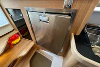 Stainless steel fridge in 2023 Nimbus C11 boat interior, featuring wood paneling and compact design.