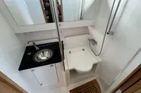 Compact bathroom in 2023 Nimbus C11 boat with sink, toilet, and shower.