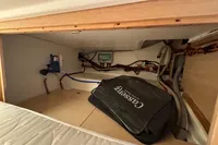Interior storage compartment of 2023 Nimbus C11 boat with equipment and a black bag.