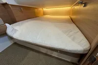 Cozy cabin bed with soft lighting in 2023 Nimbus C11 boat interior.