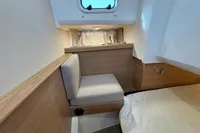 Cozy interior of 2023 Nimbus C11 boat with wooden accents and seating.