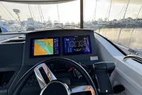 Cockpit view of 2023 Nimbus C11 boat with navigation screens in a marina setting.