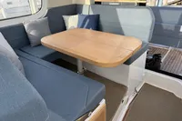 Cozy seating area with wooden table in 2023 Nimbus C11 boat interior.