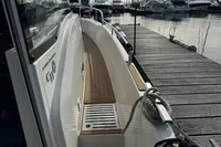2023 Nimbus C11 boat docked at marina with wooden deck and mooring rope.