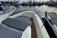 Nimbus C11 2023 boat docked in marina, featuring spacious deck and sleek design.