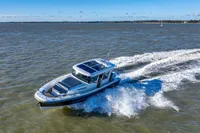 2023 Nimbus C11 boat cruising on open water under clear blue skies.