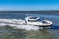 2023 Nimbus C11 boat cruising on open water under a clear blue sky.