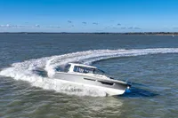 2023 Nimbus C11 boat cruising on open water under clear blue skies.