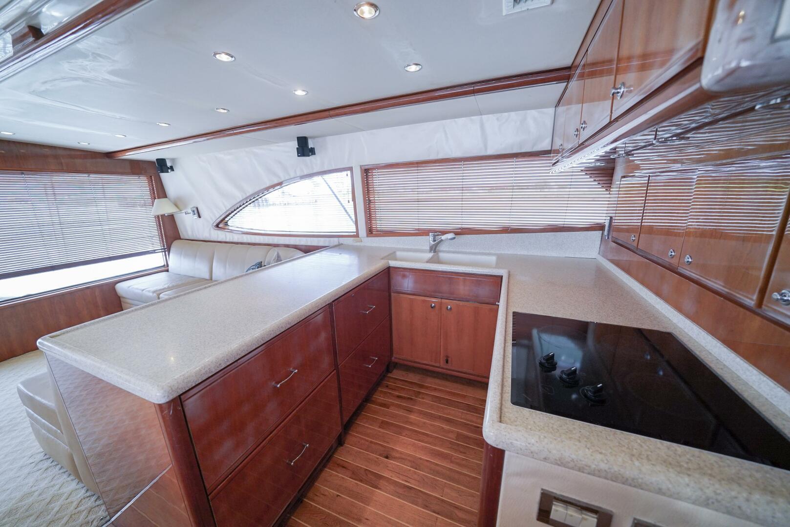 Luxurious kitchen interior of 2007 Bertram 510 Convertible yacht with wood cabinetry and modern appliances.