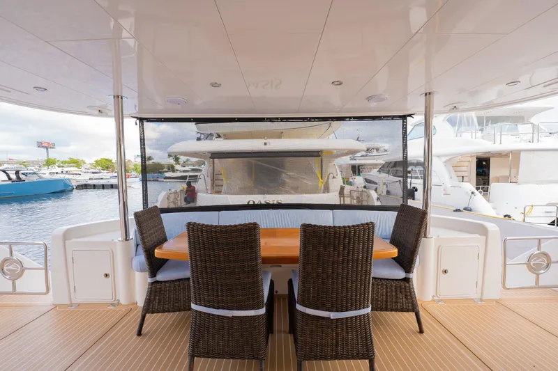 Mystic Soul Yacht Photos Pics Outdoor dining area on 2019 Horizon PC52 yacht with wicker chairs and wooden table.