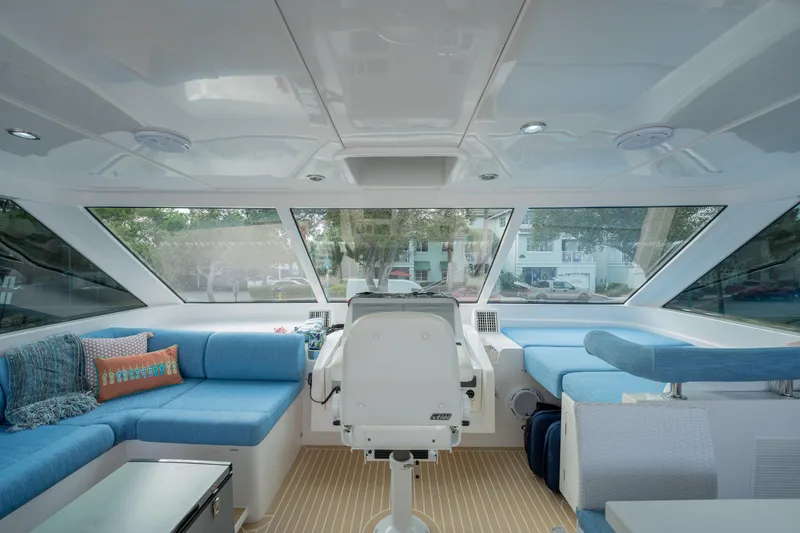 Mystic Soul Yacht Photos Pics Luxurious interior of 2019 Horizon PC52 yacht with blue seating and panoramic windows.